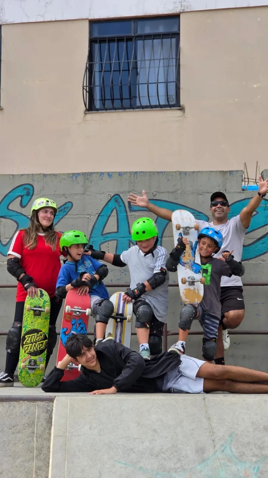 Ravenga com uma turma de alunos kids, todos de capacete e skate na mão